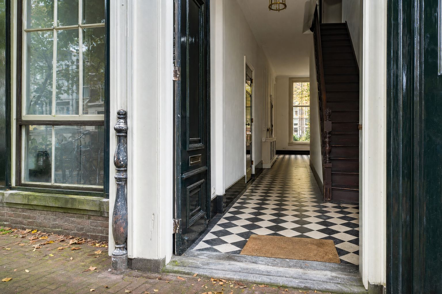 Sfeerbeeld van de gang van een grachtenpand met een zwart-witte marmeren vloer